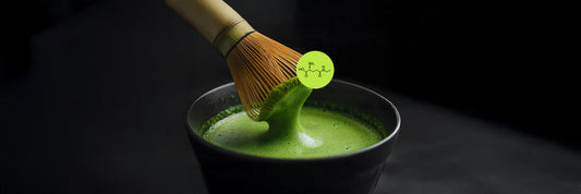 Preparing Japanese matcha tea with a bamboo whisk and an overlay of the L-theanine amino acid molecular structure.