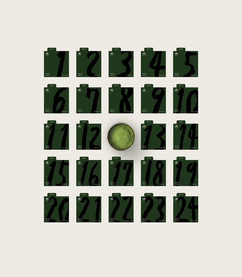 A dark green holiday gift set packaging layout on a light beige background, featuring an open inner box with printed text, a red outer box decorated with a green Christmas tree, a dark green box, a small black item, and a matching green card or booklet.